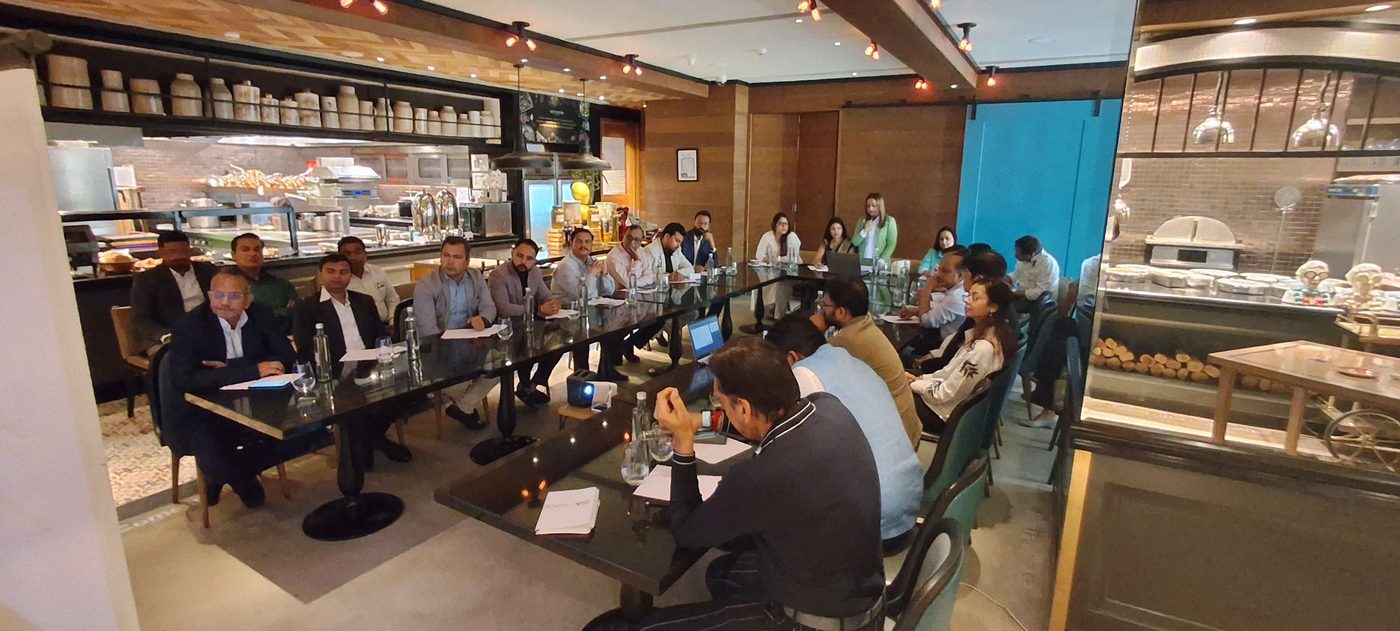 Members seated along a long table at a morning meeting